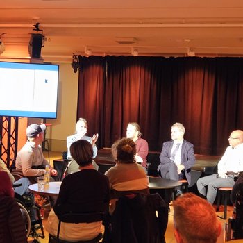 4 Podiumsteilnehmende und 1 Moderator und Gebärdendolmetscherin