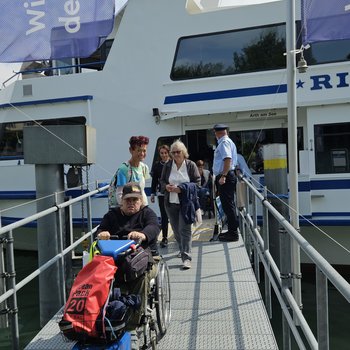 Eine Rollstuhlfahrende beim Schiffsausstieg