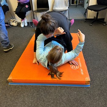 Rollstuhlfahrerin liegt am Boden und testet wie sie sich wehren kann