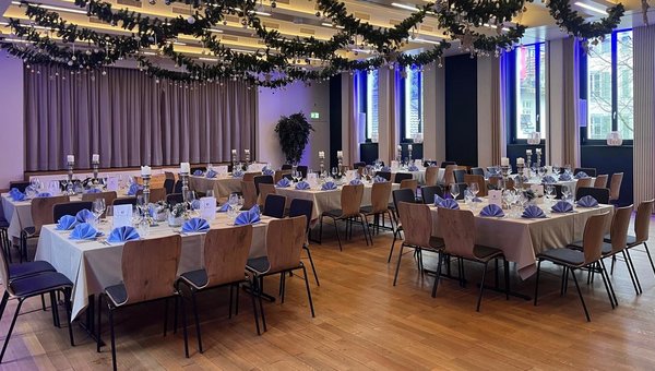 Weihnächtlich geschmückter Saal und Tische