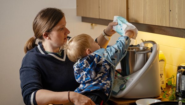 Mutter im Rollstuhl mit Kind in der Küche