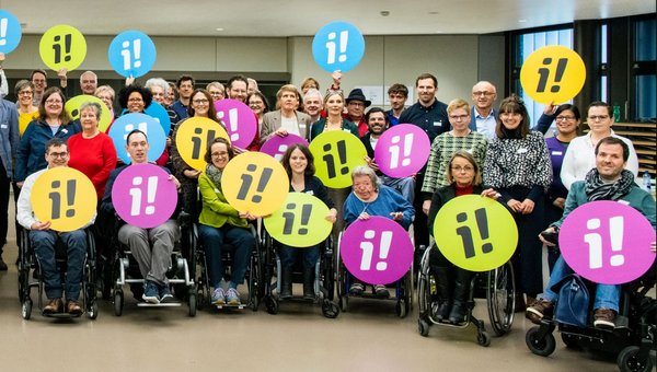 Foto mit vielen Menschen, welche für die Inklusions-Initiative werben