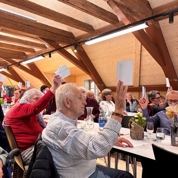 Die Aktivmitglieder erheben den Stimmzettel 