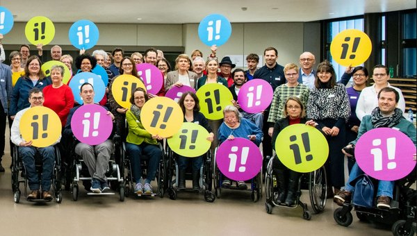 Foto mit vielen Menschen, welche für die Inklusions-Initiative werben