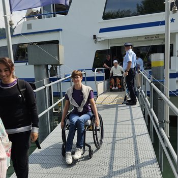 Personen und Rollstuhlfahrende verlassen das Schiff