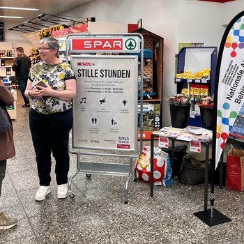 Eine Person informiert eine Kundin über die Stille Stunde